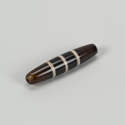 Lot 1511 - A TIBETAN AGATE ‘CHUNG DZI’ BEAD, c. 500-1000 CE