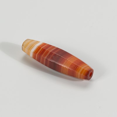 Lot 1198 - A CYLINDRICAL BANDED AGATE BEAD, 19TH CENTURY OR EARLIER