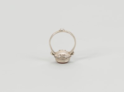 Lot 1318 - A CARNELIAN INTAGLIO INSET PERSIAN SILVER RING