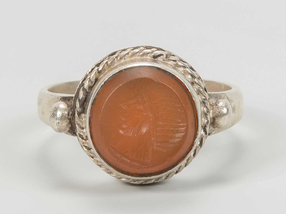 Lot 1318 - A CARNELIAN INTAGLIO INSET PERSIAN SILVER RING
