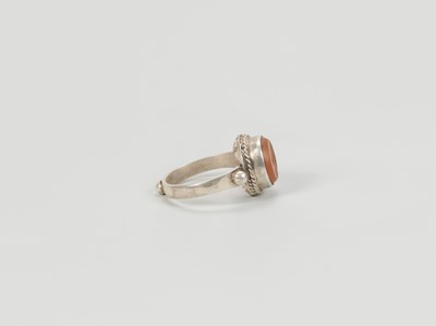 Lot 1318 - A CARNELIAN INTAGLIO INSET PERSIAN SILVER RING