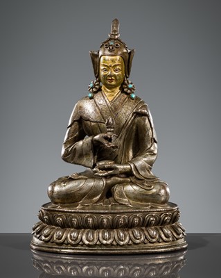 Lot 18 - AN INSCRIBED AND INLAID SILVERED BRONZE FIGURE OF PADMASAMBHAVA, TIBET, 17TH-18TH CENTURY