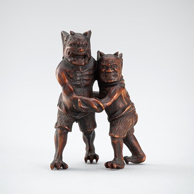 Lot 536 - A WOOD NETSUKE OF TWO ONI WRESTLNG