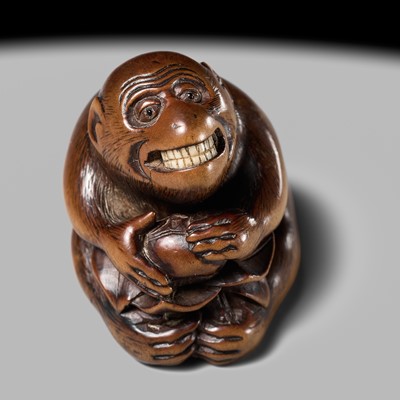 Lot 144 - AN AMUSING WOOD NETSUKE OF A MONKEY EATING A PERSIMMON