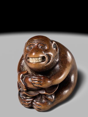 Lot 144 - AN AMUSING WOOD NETSUKE OF A MONKEY EATING A PERSIMMON