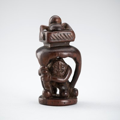 MIWA: A WOOD NETSUKE OF ONI COWERING BENEATH A TABLE