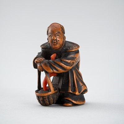 Lot 543 - A WOOD AND CORAL NETSUKE OF A KARAKO WITH BASKET