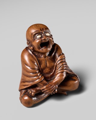 Lot 105 - A SUPERB WOOD NETSUKE OF A YAWNING DARUMA, CIRCLE OF DOSHO OR SANSHO