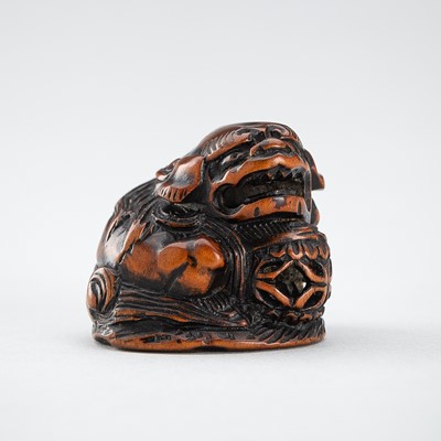 Lot 514 - MINKOKU: A WOOD NETSUKE OF A SHISHI WITH BALL