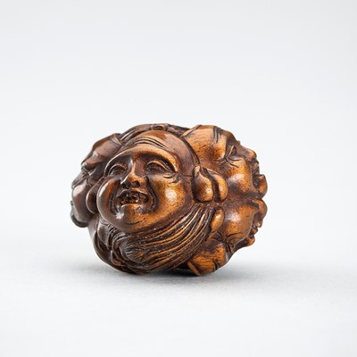 Lot 477 - A SIGNED WOOD NETSUKE OF A CLUSTER OF SHICHIFUKUJIN MASKS