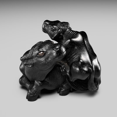 Lot 115 - MASANAO: A MASTERFUL EBONY WOOD NETSUKE OF A RECUMBENT COW WITH CALF