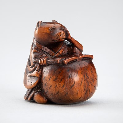 Lot 499 - AN AMUSING WOOD NETSUKE OF A TANUKI READING A MANUSCRIPT