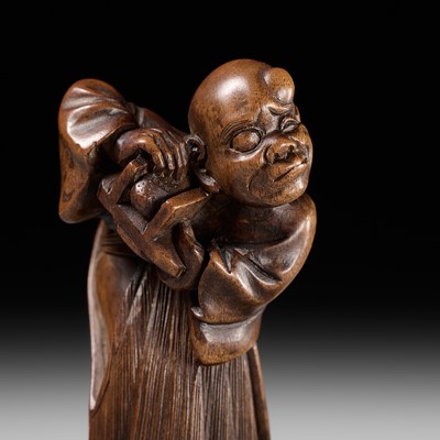 Lot 189 - A FINE WOOD NETSUKE OF A BLIND MAN WITH A STONE IN HIS GETA, ATTRIBUTED TO SHOKO