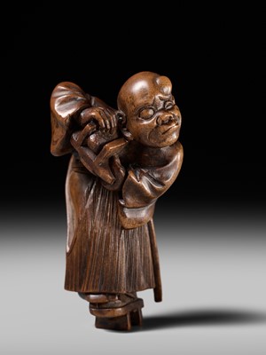 Lot 189 - A FINE WOOD NETSUKE OF A BLIND MAN WITH A STONE IN HIS GETA, ATTRIBUTED TO SHOKO