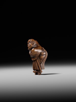 Lot 189 - A FINE WOOD NETSUKE OF A BLIND MAN WITH A STONE IN HIS GETA, ATTRIBUTED TO SHOKO