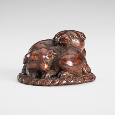 Lot 1546 - TOMOSADA: A WOOD NETSUKE OF TWO PUPPIES ON A STRAW MAT