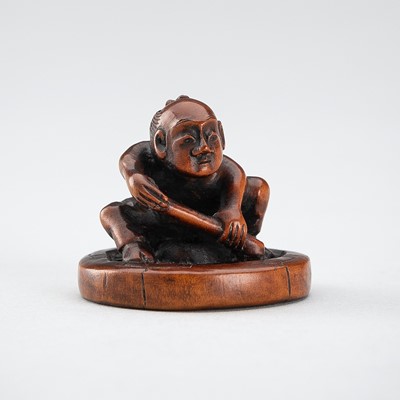 Lot 520 - HOKEI: A WOOD NETSUKE OF A MAN FIXING A WHEEL