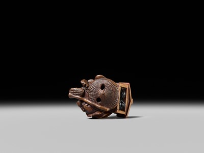 Lot 231 - AN AMUSING WOOD KARAKURI (TRICK) NETSUKE OF A MASK SELLER