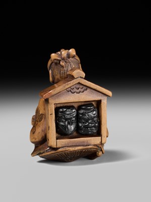 Lot 231 - AN AMUSING WOOD KARAKURI (TRICK) NETSUKE OF A MASK SELLER