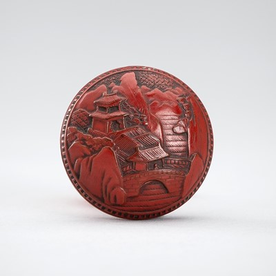 A TSUISHU (CARVED RED LACQUER) MANJU NETSUKE WITH PAVILIONS