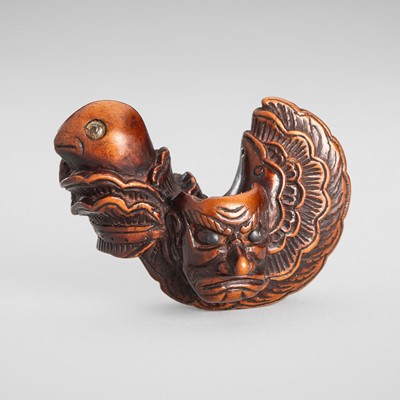 Lot 1594 - A WOOD NETSUKE OF A BUGAKU HELMET (TORIKABUTO)