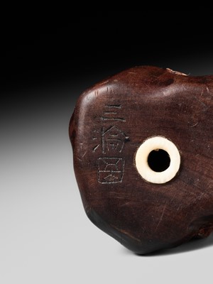 Lot 218 - MIWA: AN INLAID WOOD NETSUKE OF AN OLD CHINESE COIN AND DARUMA (ZENI AND ZEN)