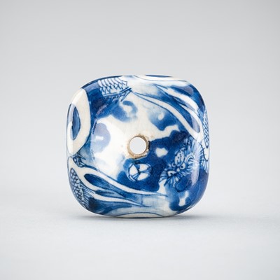 Lot 638 - A HIRADO BLUE AND WHITE MANJU NETSUKE WITH A DRAGON