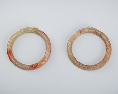 Lot 1854 - A PAIR OF PALE CELADON AND RUSSET ‘TWISTED ROPE’ JADE BANGLES, c. 1900s