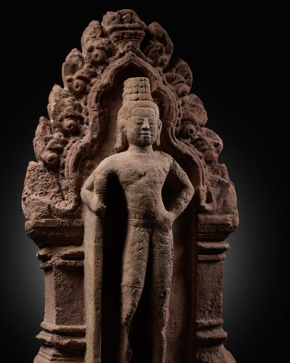 Lot 341 - A RED SANDSTONE ‘GUARDIAN DEITY’ ANTEFIX, BANTEAY SREI