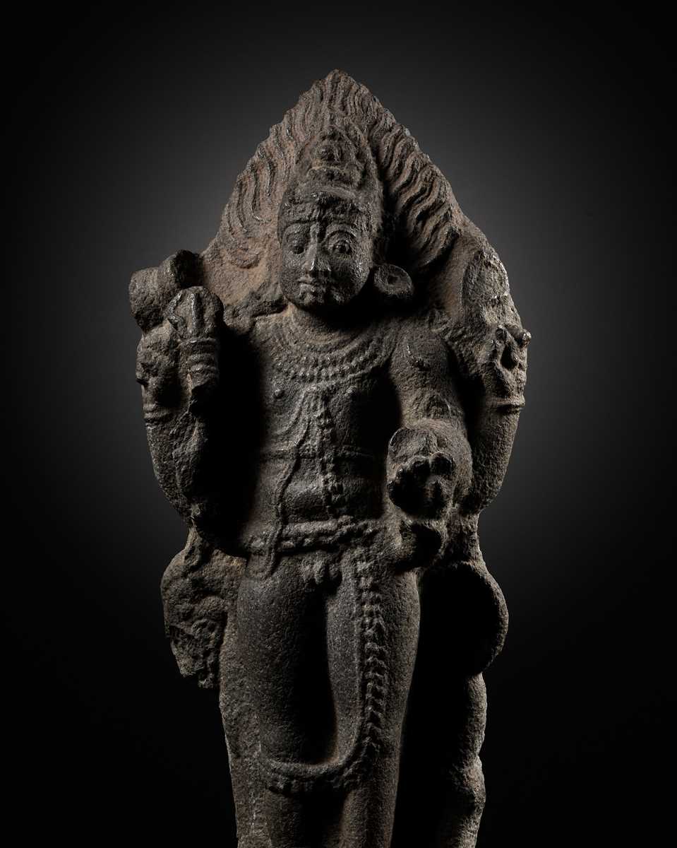 Lot 275 - A MONUMENTAL GRANITE FIGURE OF SHIVA AS BHAIRAVA, CHOLA PERIOD