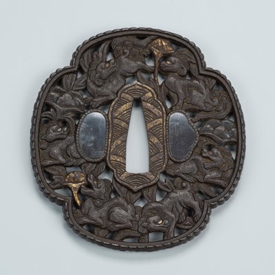 Lot 1490 - AN IRON SUKASHI TSUBA DEPICTING SHISHI WITH LOTUS BLOSSOMS