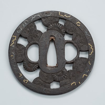 Lot 1480 - AN IRON SUKASHI TSUBA WITH CHRYSANTHEMUMS AND CRUSHING WAVES