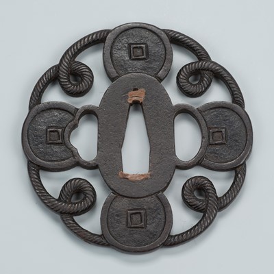 Lot 1474 - AN IRON SUKASHI TSUBA WITH COINS