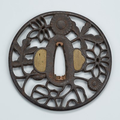 Lot 1542 - AN IRON SUKASHI TSUBA WITH FLORAL AND FOLIAGE MOTIFS