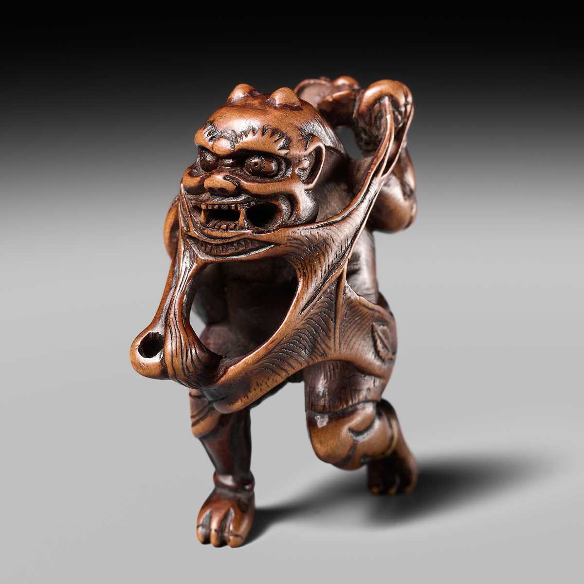 Lot 153 - A VERY RARE WOOD NETSUKE OF AN ONI CAUGHT IN A SPIDERWEB