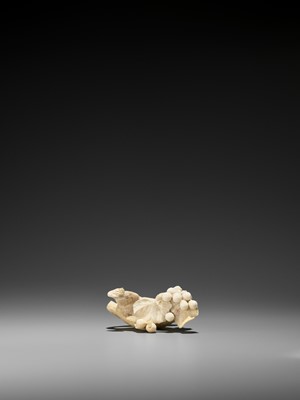 Lot 224 - EIICHI: AN IVORY OKIMONO OF A SQUIRREL GNAWING AT GRAPES