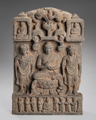 Lot 1303 - A GANDHARA-STYLE GRAY SCHIST TRIAD OF BUDDHA SHAKYAMUNI WITH BODHISATTVAS