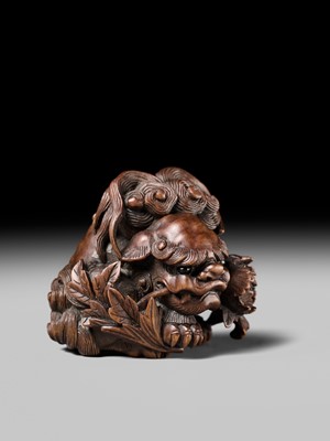 Lot 184 - SUKETADA: A SUPERB WOOD NETSUKE OF A SHISHI WITH PEONY