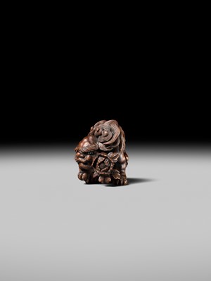 Lot 184 - SUKETADA: A SUPERB WOOD NETSUKE OF A SHISHI WITH PEONY