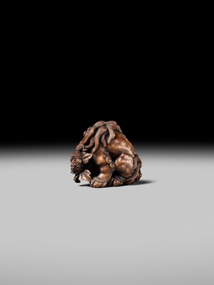 Lot 184 - SUKETADA: A SUPERB WOOD NETSUKE OF A SHISHI WITH PEONY