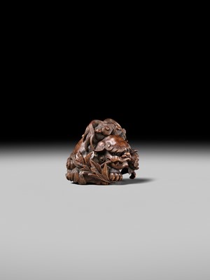 Lot 184 - SUKETADA: A SUPERB WOOD NETSUKE OF A SHISHI WITH PEONY