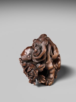 Lot 184 - SUKETADA: A SUPERB WOOD NETSUKE OF A SHISHI WITH PEONY