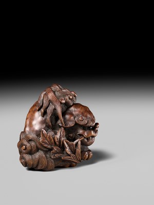 Lot 184 - SUKETADA: A SUPERB WOOD NETSUKE OF A SHISHI WITH PEONY