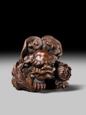 Lot 184 - SUKETADA: A SUPERB WOOD NETSUKE OF A SHISHI WITH PEONY