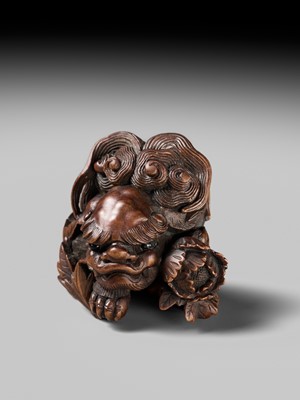 Lot 184 - SUKETADA: A SUPERB WOOD NETSUKE OF A SHISHI WITH PEONY