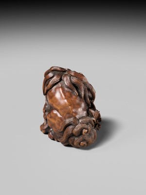 Lot 184 - SUKETADA: A SUPERB WOOD NETSUKE OF A SHISHI WITH PEONY