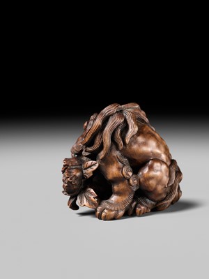 Lot 184 - SUKETADA: A SUPERB WOOD NETSUKE OF A SHISHI WITH PEONY