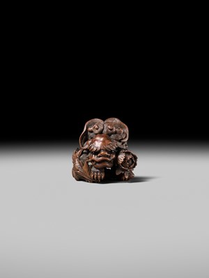 Lot 184 - SUKETADA: A SUPERB WOOD NETSUKE OF A SHISHI WITH PEONY