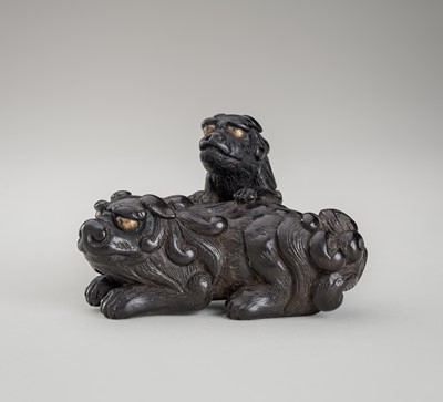 Lot 461 - A SIGNED EBONY WOOD NETSUKE OF A SHISHI WITH CUB