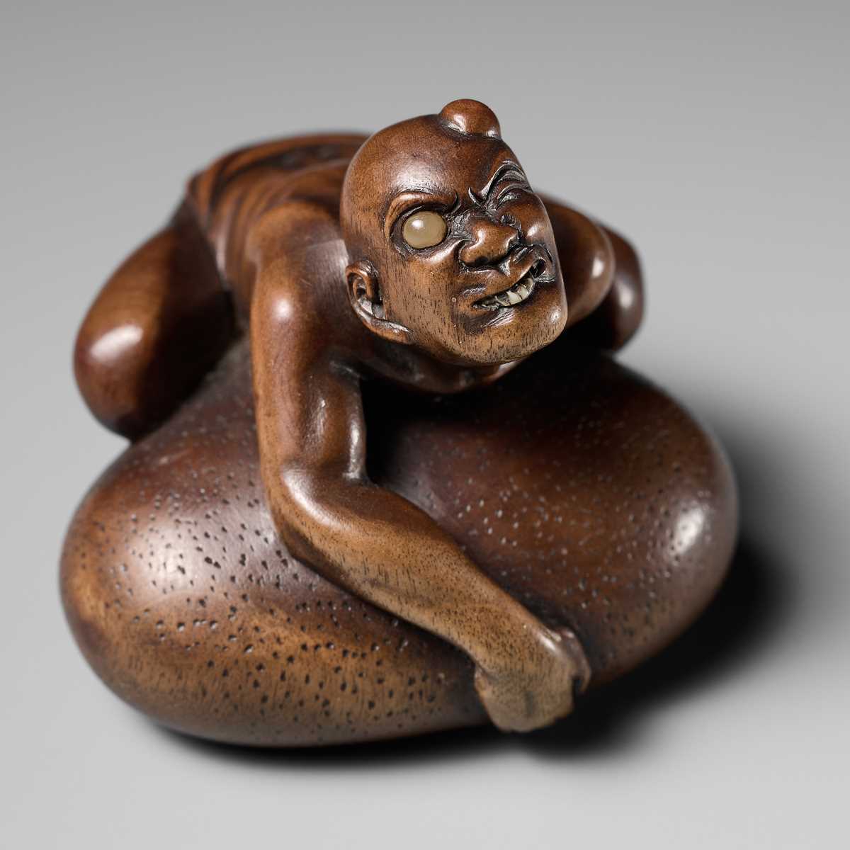 Lot 188 - SHOKO: A SUPERB WOOD NETSUKE OF A BLIND MAN LIFTING A CHIKARAISHI